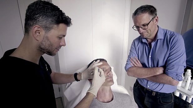 Dr Wassim Taktouk injects dermal filler into a patient's tear trough area, watched by Dr Michael Mosley 